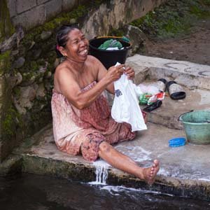 Jerry van de Beek - Woman Washing Clothes in a River in Indonesia